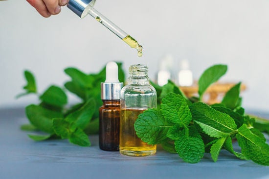 seçici odaklanma ile mavi zeminde nane esansiyel yağı şişesi