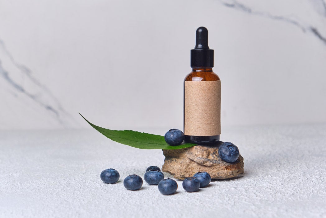 yanında bir koku kavanozu olan ahşap yüzeyde yaban mersinleri