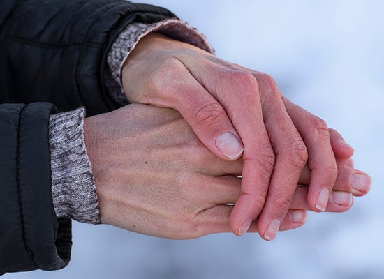 Karda donmuş ellerini gösteren kişi