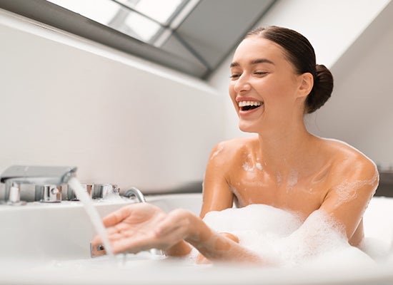 Banyo köpüğü alarak mutlu kadın