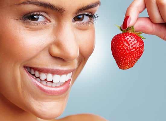 genç kadın çilek tutarken gülümsüyor