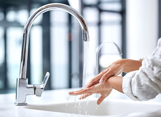 Kadın ellerini suyla yıkıyor