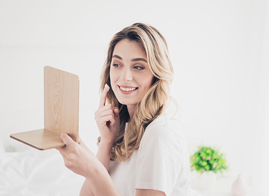 Gülümseyen kadın krem ​​sürüyor