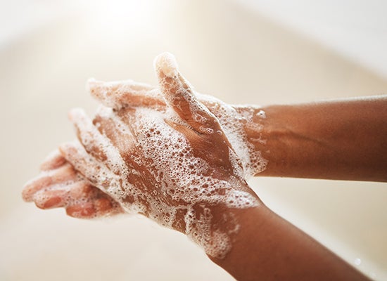 ellerini su ve sabunla yıkayan kişi