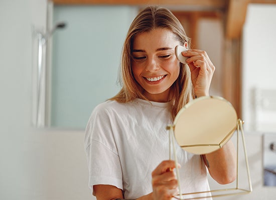 Gülümseyen kadın yüzünü pamukla siliyor